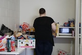 A woman in a black shirt in a motel kitchen