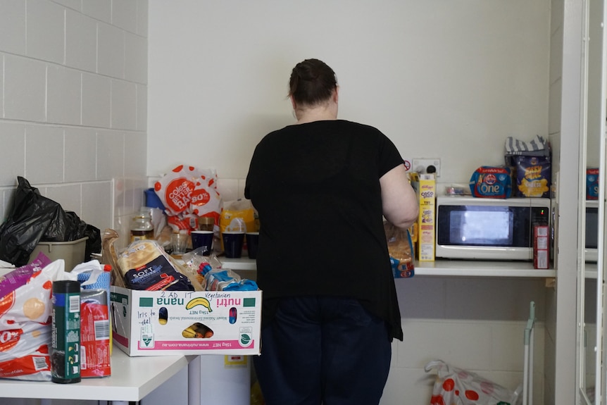 A woman in a black shirt in a motel kitchen