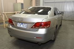 A silver Toyota sedan is parked in a garage with number plate 1EB 8ZD.