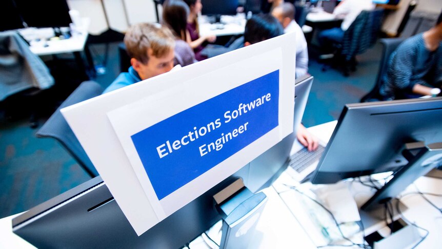 computer desks with sign: Elections Software Engineer