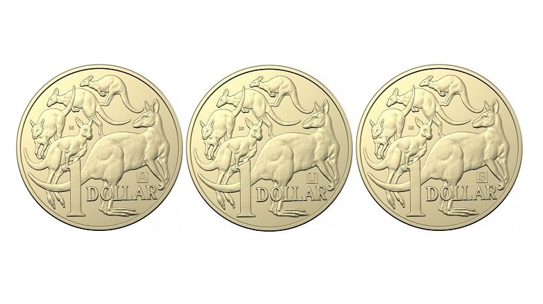 Three Australian $1 coins. Each one has the letter A U or S and the number 35 marked on it between depictions of kangaroos