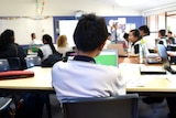 An image of a classroom showing the backs of young students. 