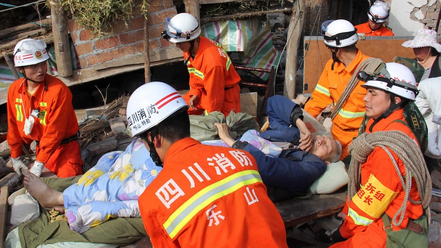 Rescuers carry carry elderly person on stretcher after Chinese quake
