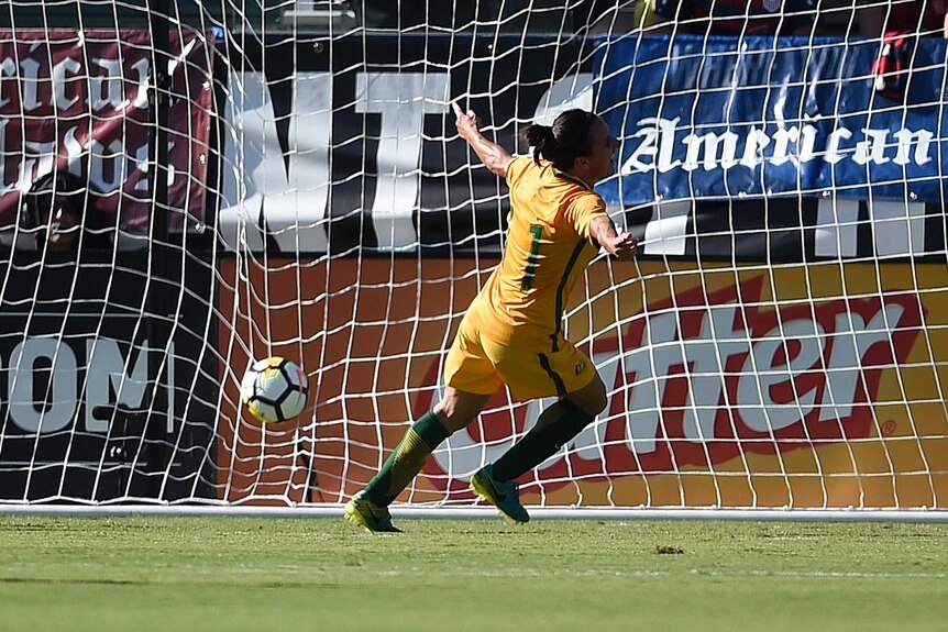 Lisa De Vanna runs away from goal with her arms spread wide.