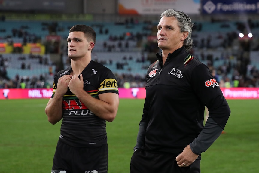 Penrith Panthers coach Ivan Cleary (right) walks with halfback Nathan Cleary on the field after losing the 2020 NRL grand final.