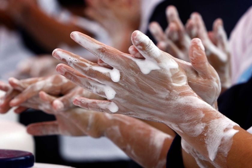 Children washing their hands with plenty of soap.