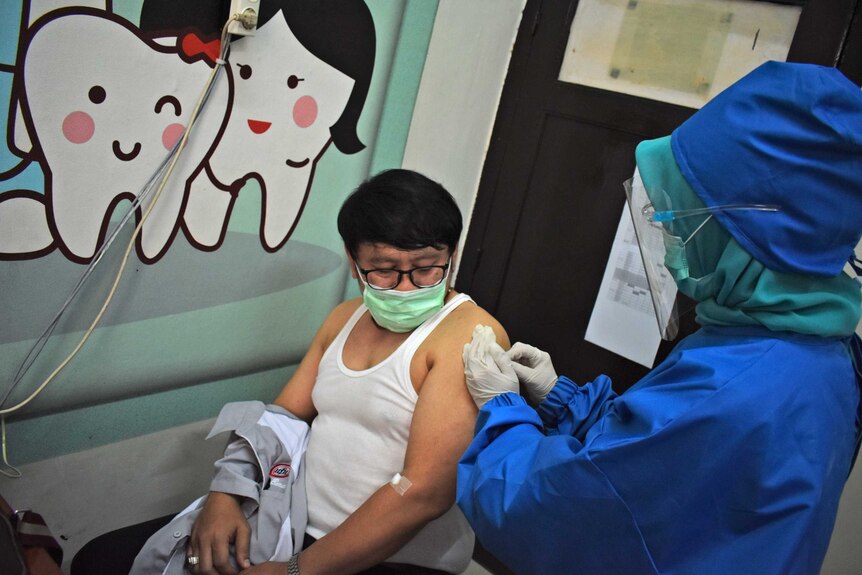 A medical worker gives coronavirus vaccine candidate to a volunteer in Bandung, West Java.
