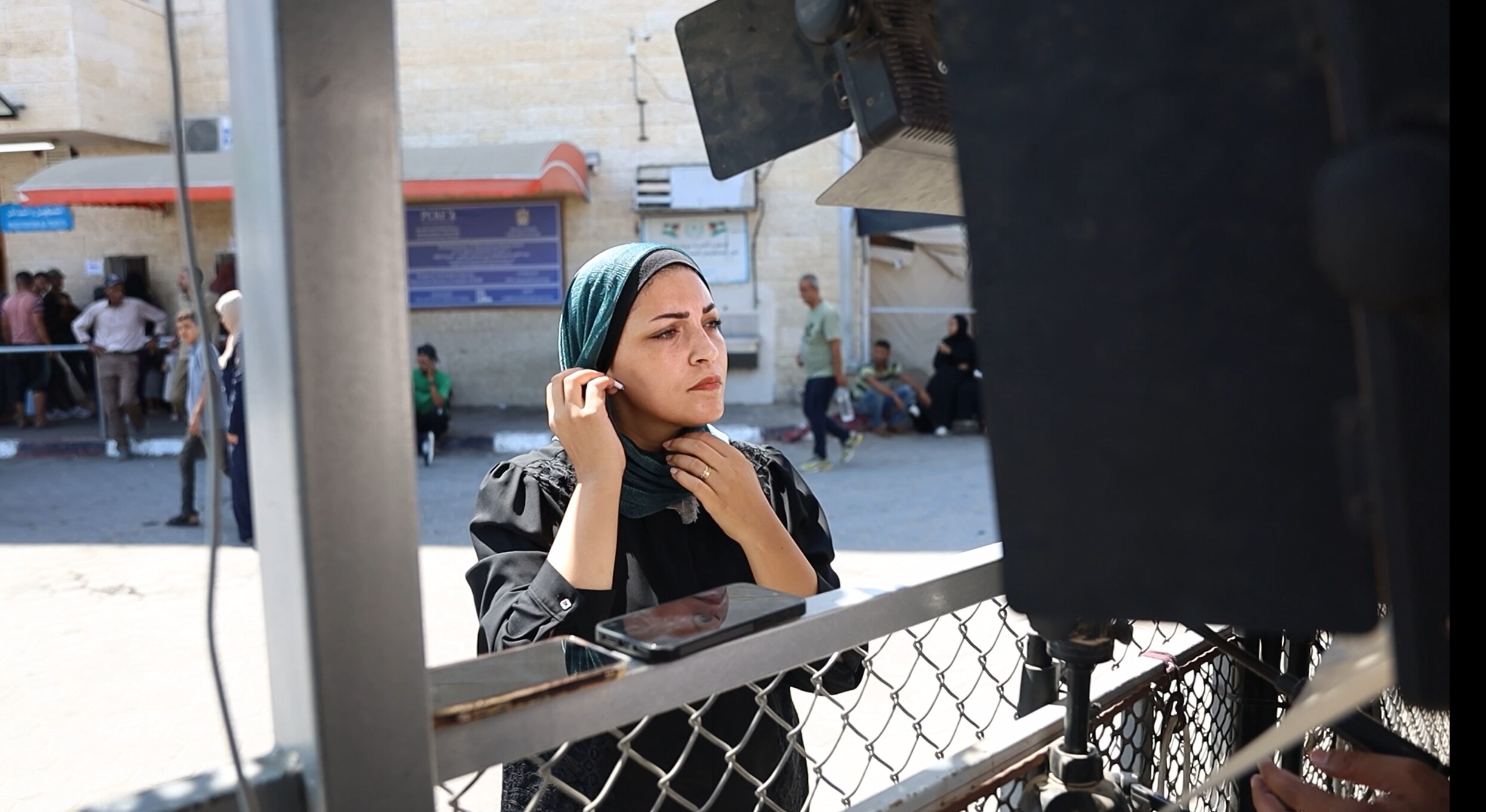 A woman in a hijab prepares herself for a tv piece