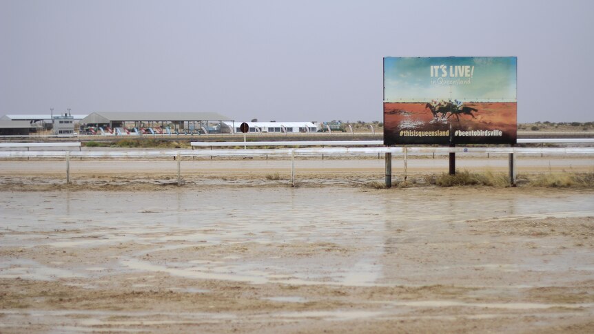 Muddy race track with Birdsville Races sign