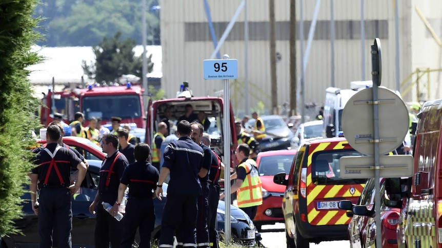 French police and firefighters gather at the entrance of the Air Products company