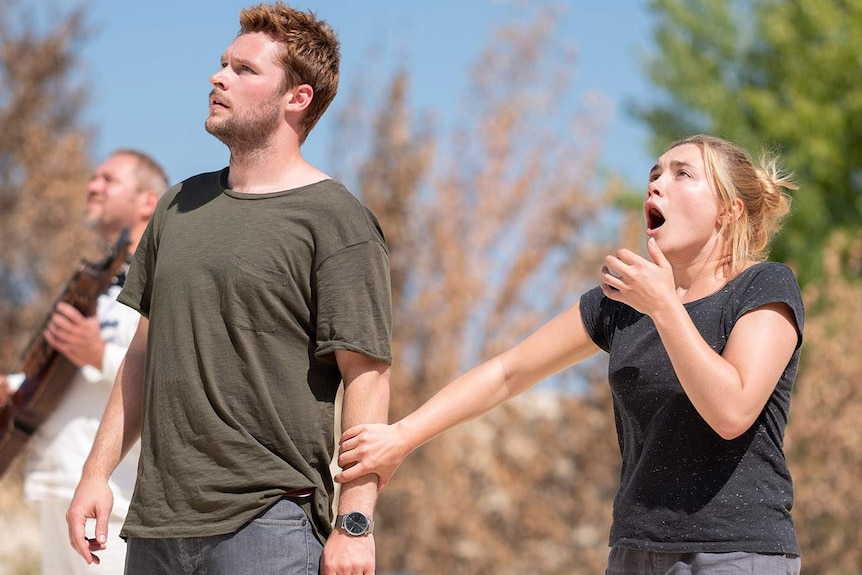 The actors look upwards at something out of frame with looks of terror on their faces.