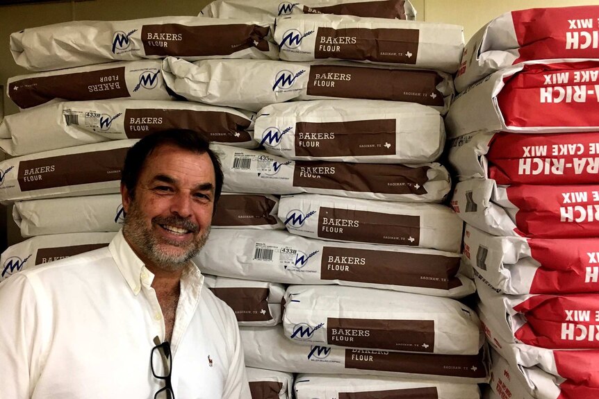 Kirk Michaelis in front of bags of flour