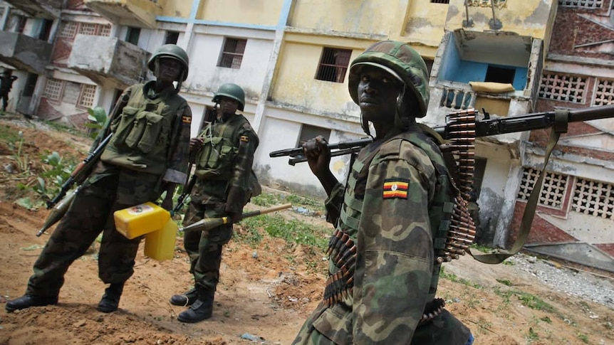 Armed soldiers walk down Mogadishu street