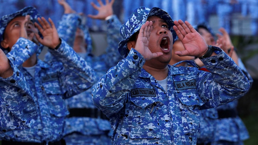 Participants of the Bela Negara - "defend the nation" - programme shout during morning exercise