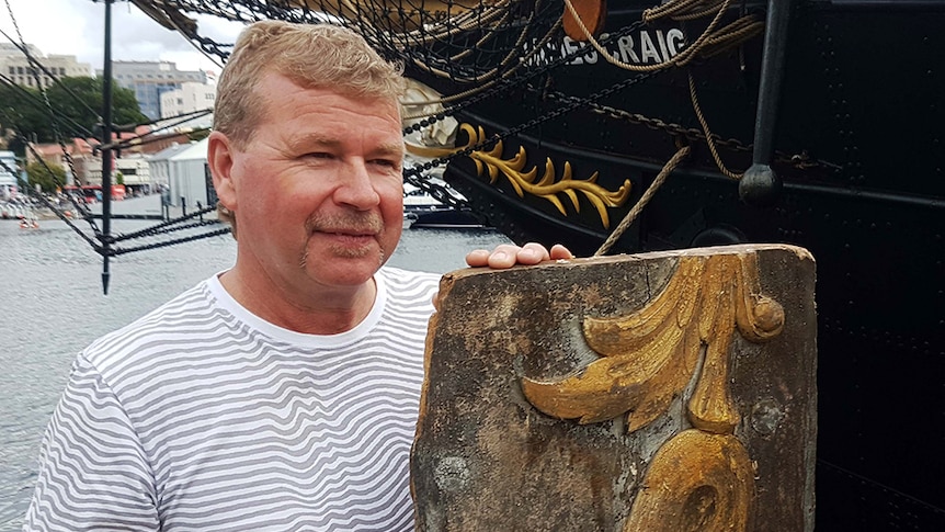 Gavin Brown holds original scroll work taken from the wreck of the James Craig