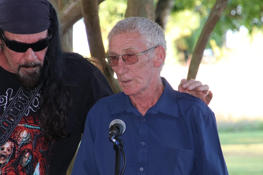 Dennis Polsen speaks into a microphone at the Russell Island memorial