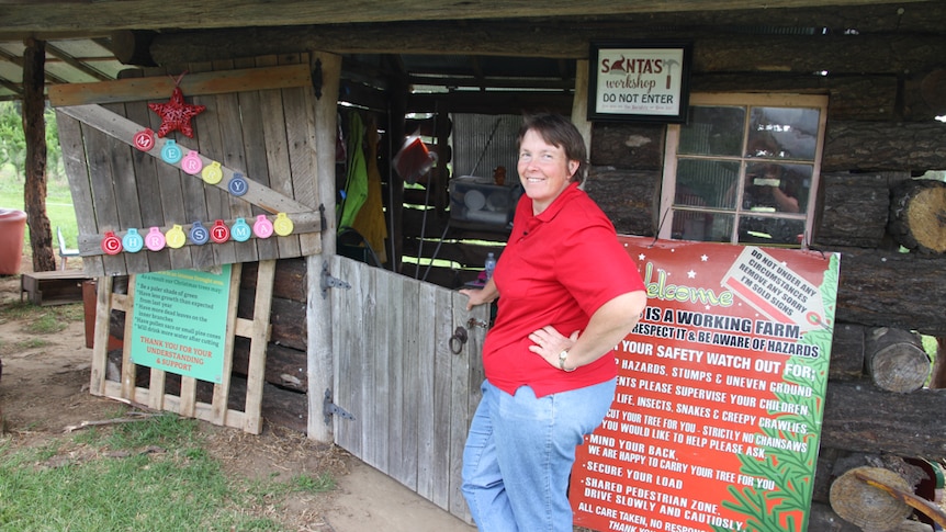 Farmer stands in front of her workshop where Christmas trees are stored once they are cut.