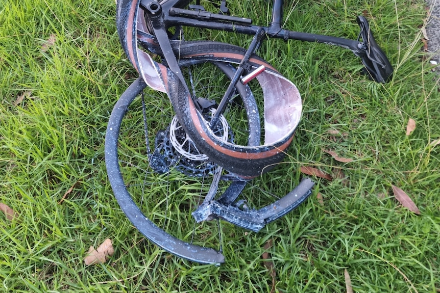 Robert Clarke's bike lies on the grass after he was hit, its back wheel appears to have been destroyed.