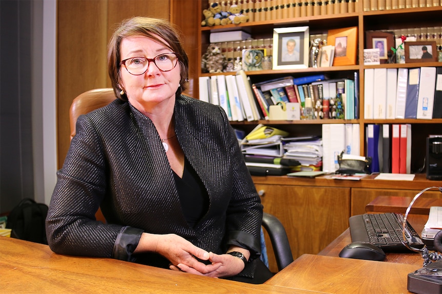 Lorraine Walker sits at a desk