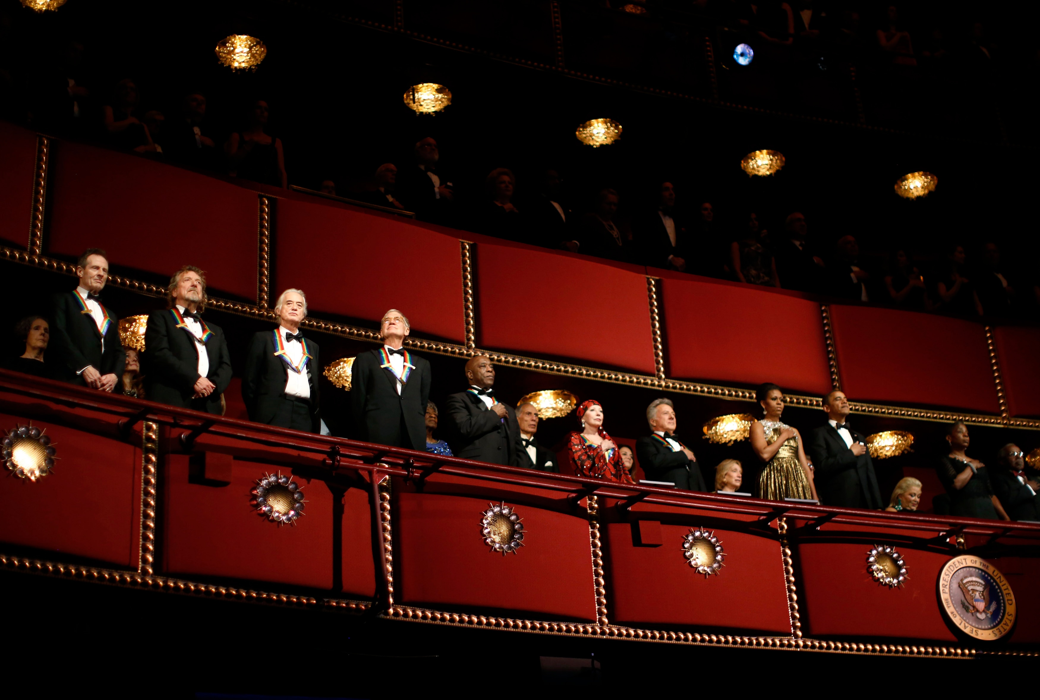 people stand up in a theatre.