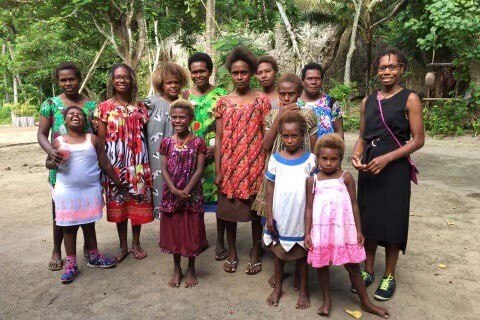 A group of Papua New Guineans women and girls stand together for a family photo.