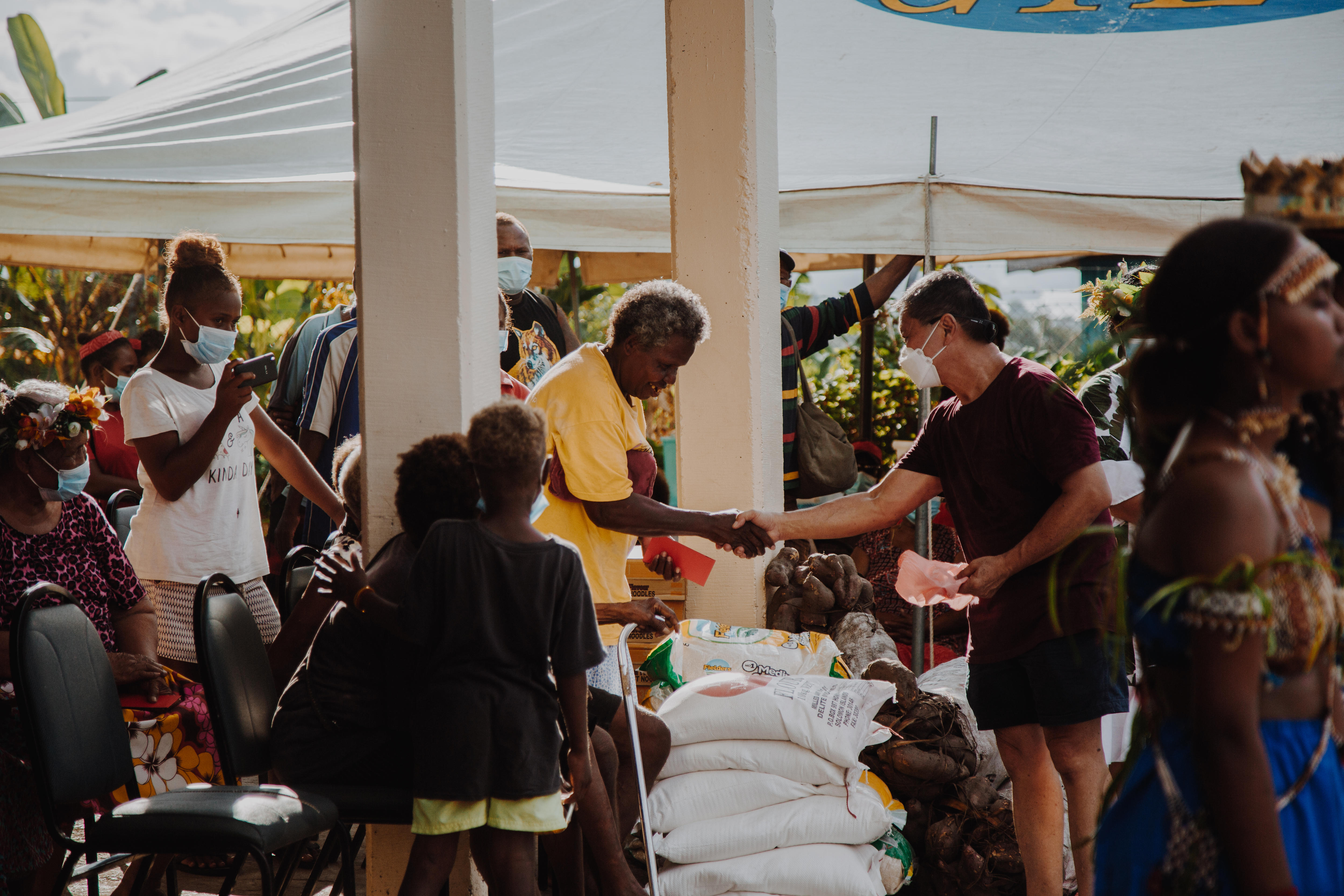And elderly woman and a man shake hands. 