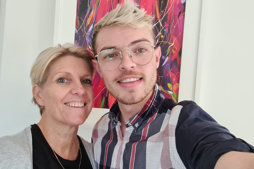 A mum and young adult son taking a selfie, smiling