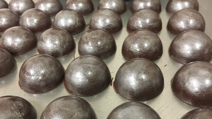 Close up of shiny silver dome chocolates.