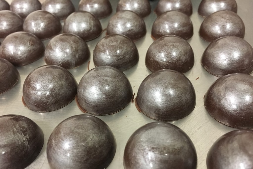 Close up of shiny silver dome chocolates.
