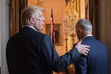Donald Trump pats Malcolm Turnbull on the back as they walk through a door.