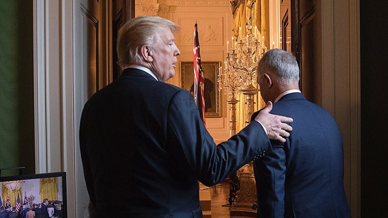Donald Trump pats Malcolm Turnbull on the back as they walk through a door.
