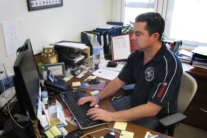 NSW Police Association president Scott Weber sits at an office desk.