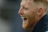 Ben Stokes smiles and claps his hands together