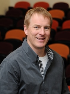 Blond haired Damian Candusso wearing a grey shirt smiling. His career has thrived working in regional Australia