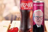 A cherry-flavoured bottle and can of Coca-Cola sold in China, with a cartoon of Warren Buffett's face on it.