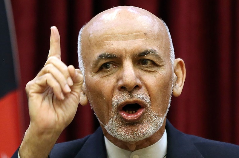 Afghan President Ashraf Ghani raises his finger as he delivers a speech.