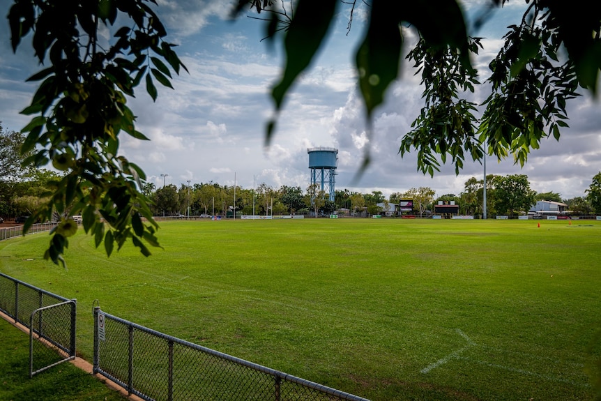 Nightcliff Oval and a blue water tank is seen with clouds overhead.