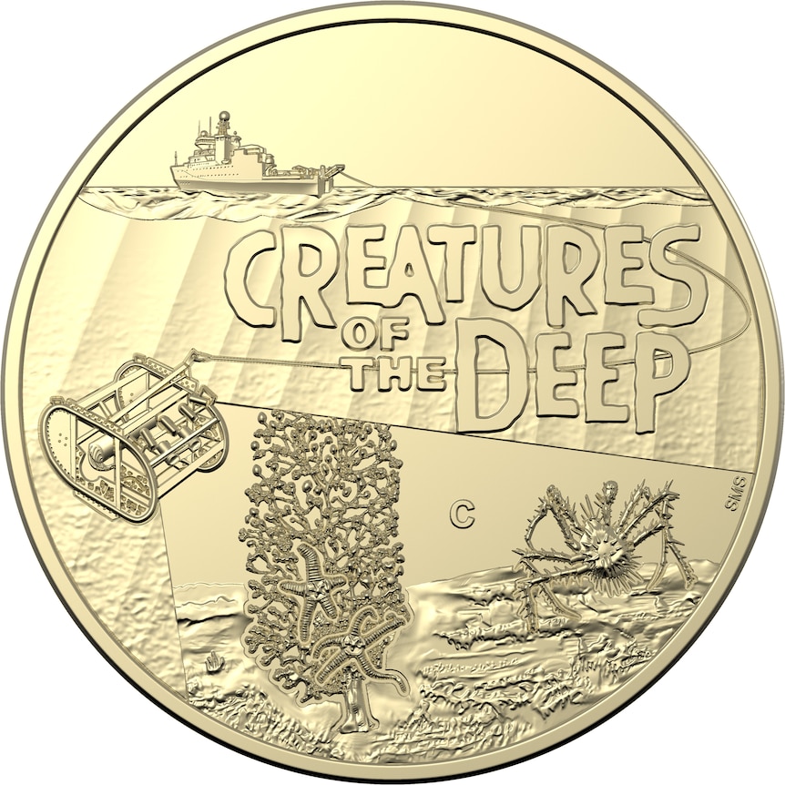 A gold coin featuring the words creatures of the deep. 
