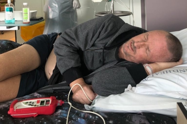 man lying in a hospital bed having treatment for Leukaemia