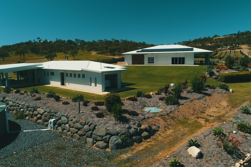 Aerial photo of two houses on a property, one with solar panels on roof. 