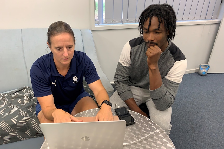 Goele Scmitz types on a a laptop as Emeke Ekezie watches on.