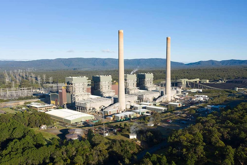 An aerial view of poweer station with two large smoke stacks