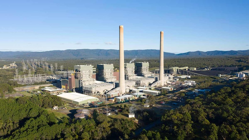 An aerial view of a power station with two large smoke stacks