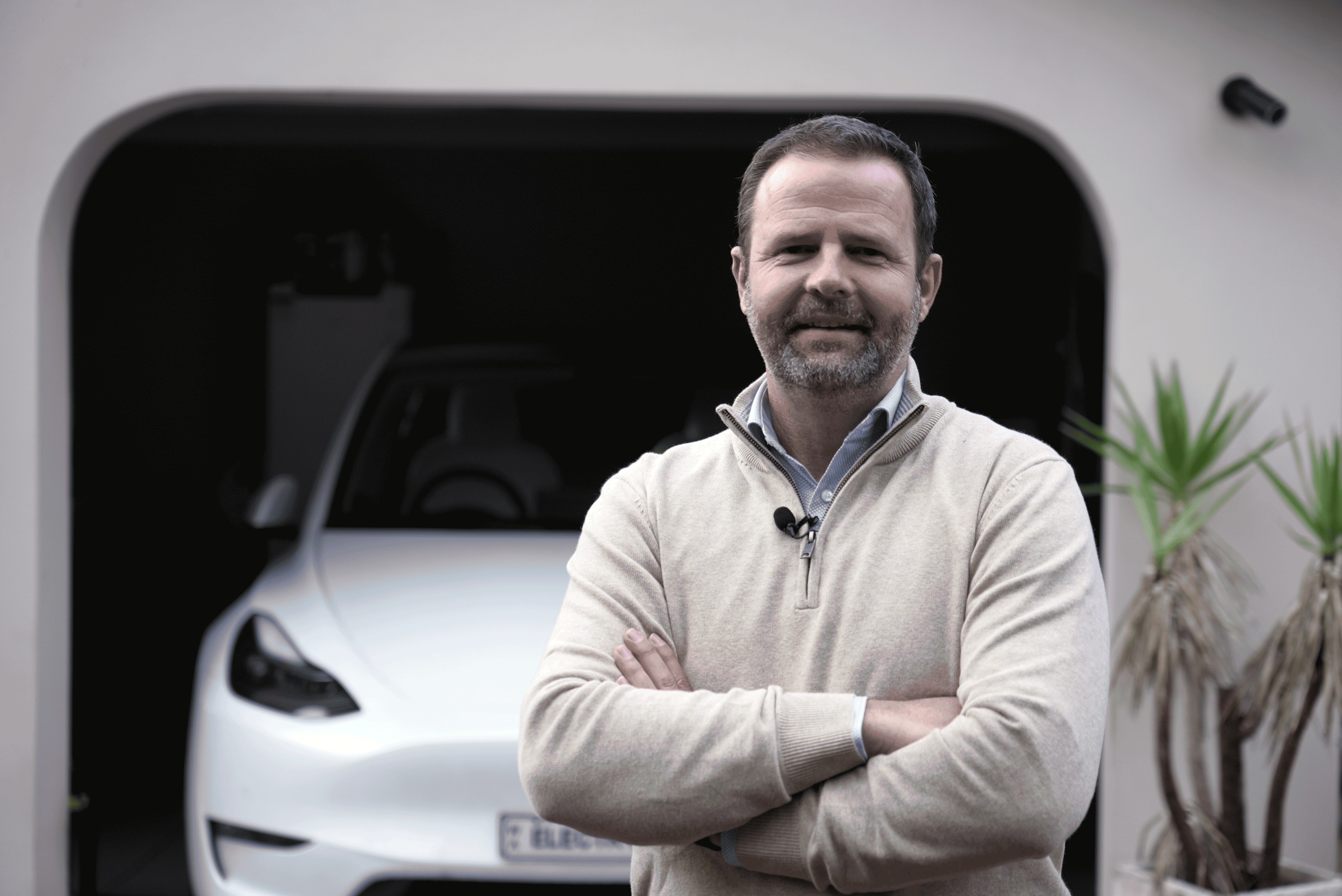 Peter Petrovsky stands in front of a car with his arms folded.