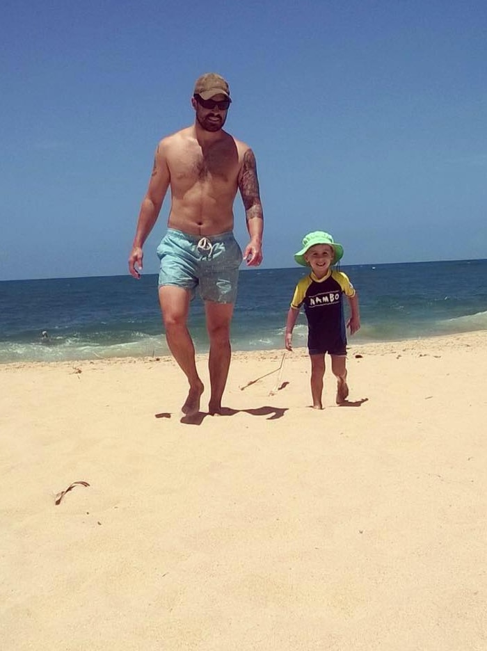 Nathaniel Beesley with son on beach.