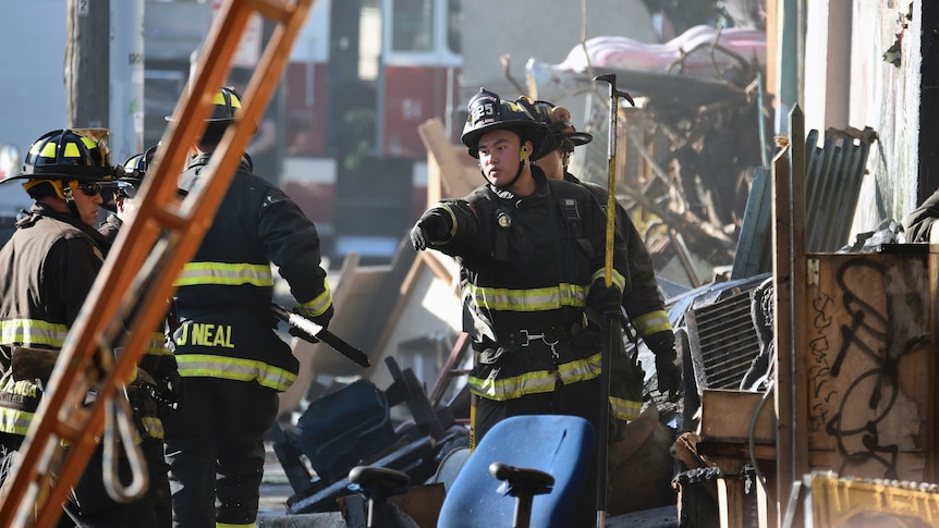 Firefighters try to assess the scene where the deadly fire tore through.