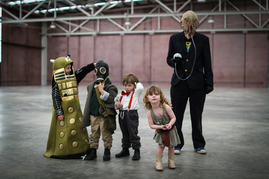 Four small children and an adult woman in costumes.