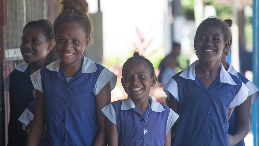 Young Pacific Island girls in blue school dresses. 