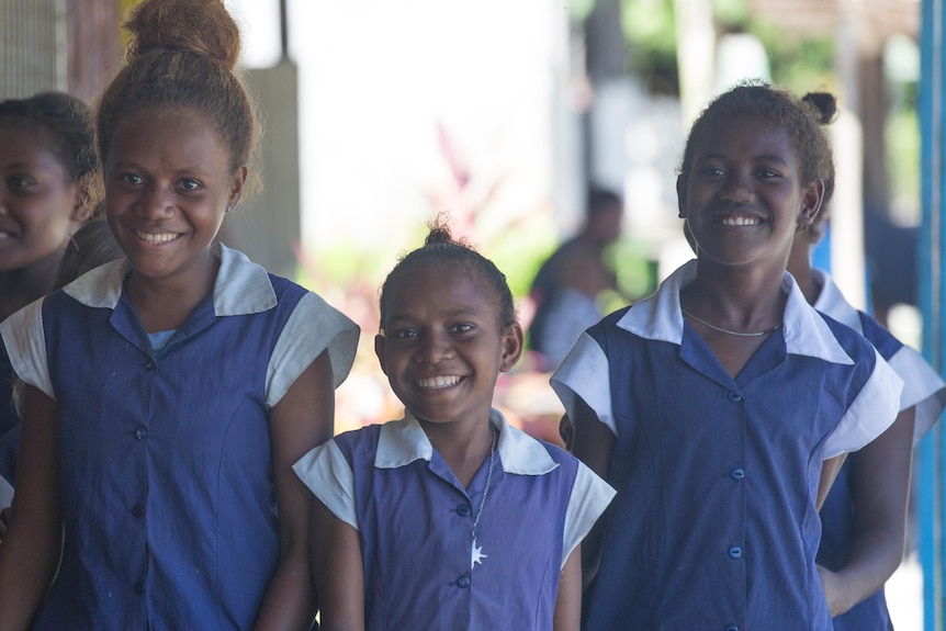 Young Pacific Island girls in blue school dresses. 