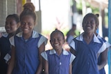 Young Pacific Island girls in blue school dresses. 